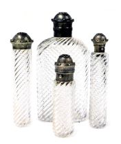 Four Victorian cut glass flasks, with Gothic silver mounts and hinged lids, the flasks of fluted for
