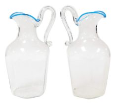 A pair of 20thC cut glass water jugs, of hexagonal form, with a scrolling handle and blue trimmed li