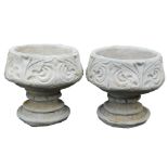 A pair of concrete circular footed planters, with leaf decoration, 39cm wide.
