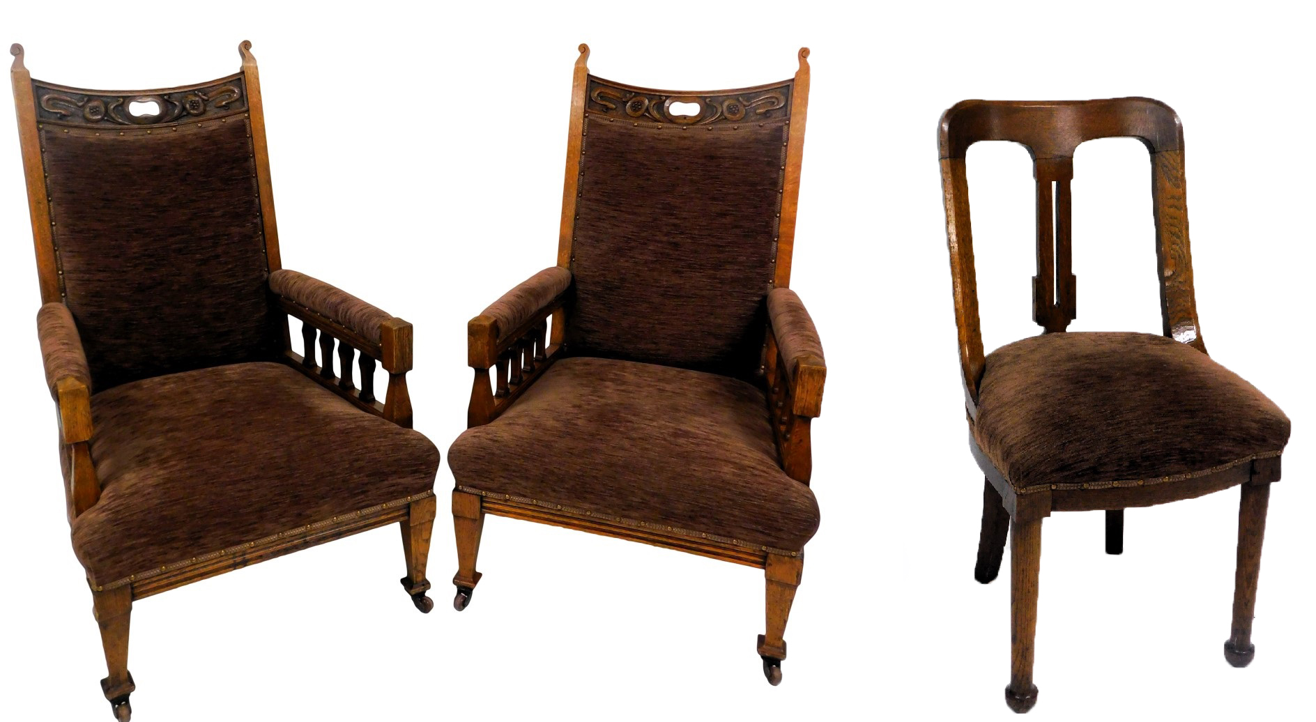 A pair of Victorian art nouveau oak armchairs, the crest rail carved with pomegranates, with overstu