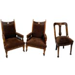 A pair of Victorian art nouveau oak armchairs, the crest rail carved with pomegranates, with overstu