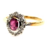 An 18ct gold ruby and diamond ring, the oval cut ruby in a basket setting with small diamonds, size