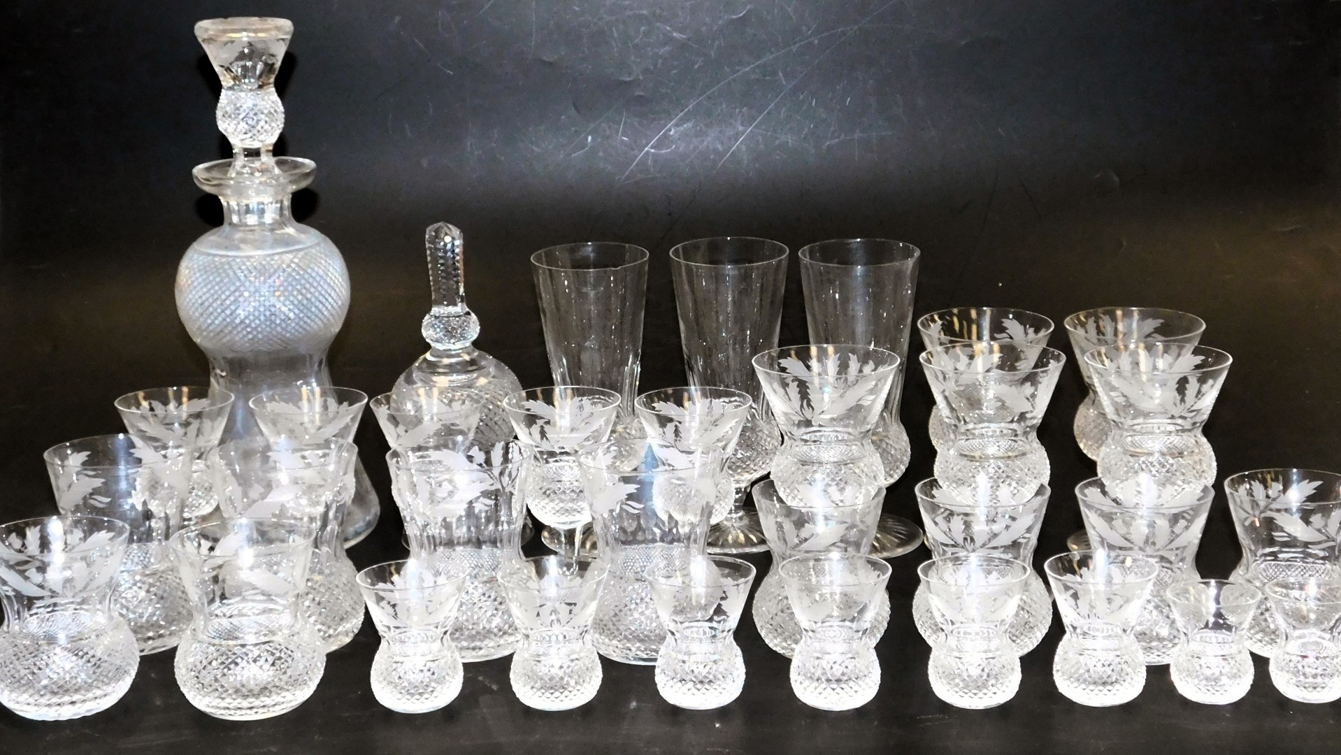 An Edinburgh Crystal Thistle Pattern suite of table glassware, including champagne flutes, red and w