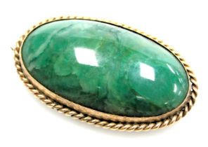 A green agate cabochon brooch, in an oval yellow metal frame, stamped 9ct, 4cm wide.