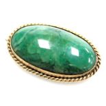 A green agate cabochon brooch, in an oval yellow metal frame, stamped 9ct, 4cm wide.