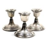 A pair of George V loaded silver candlesticks, Birmingham 1912, and a further loaded candlestick, Bi