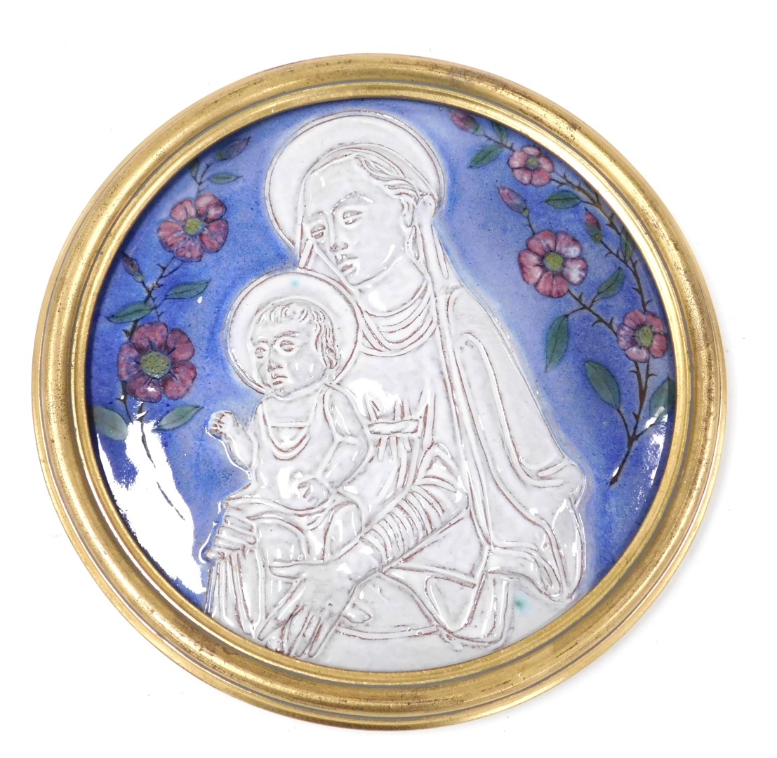 A 20thC religious pottery plaque, of circular form, depicting the Madonna and seated child, in white