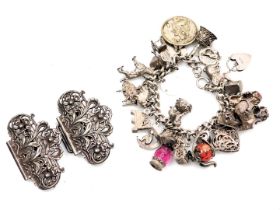 A silver curb link charm bracelet, with twenty six charms as fitted, on a heart shaped padlock clasp