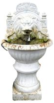 A Victorian style cast iron garden fountain, of demi lune form, cast with the head of a lion, above