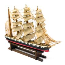 A wooden scale model of a clipper ship, fully rigged, with sails, on a wooden stand, 90cm wide.