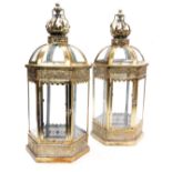 A pair of metal and glass lanterns, with crown finials, of hexagonal form, with pierced foliate band