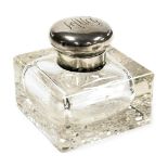 An early 20thC cut glass inkwell, with a hinged silver lid, monogram engraved, bears partial hallmar