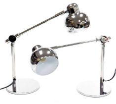 A pair of white metal angular desk lamps, raised on circular bases, 26cm high.