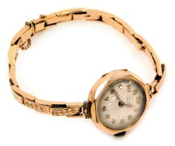 A mid century 9ct rose gold lady's wristwatch, for W H Bird of Grantham, circular silvered dial bear