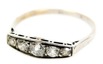 An early 20thC diamond five stone ring, channel set in white metal, approximately ¼ct, size M, 1.1g.