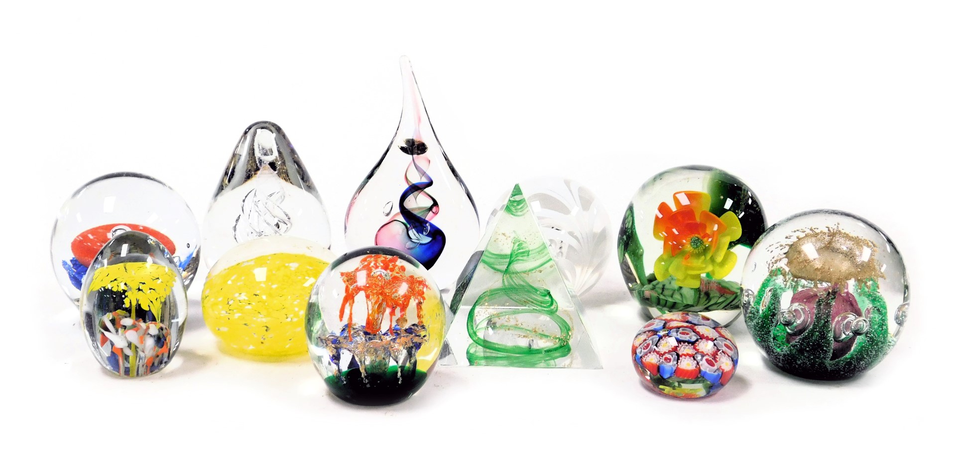 A group of glass paperweights, including a Tablonski tear shaped weight, a pyramid weight and floral