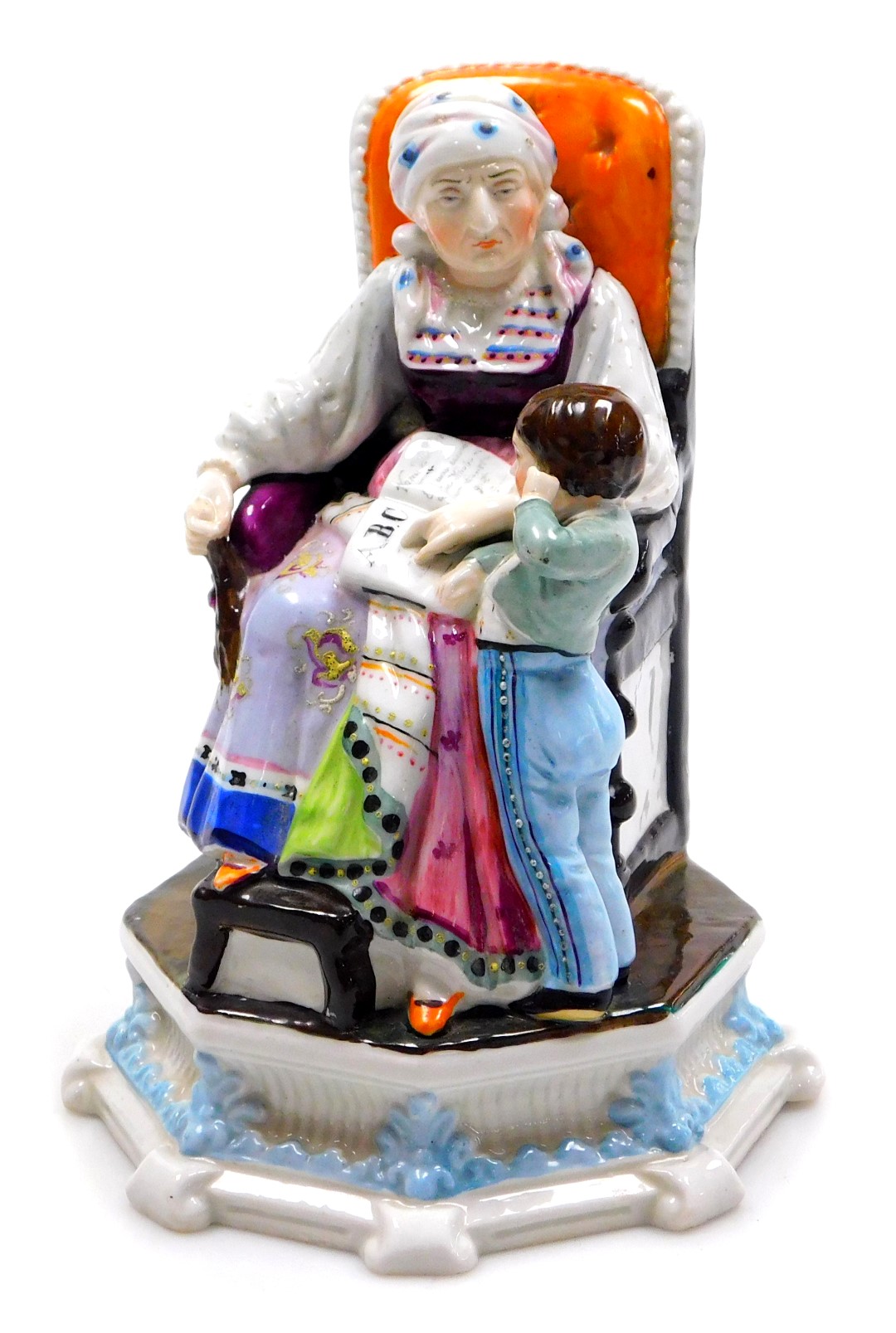 A late 19thC continental porcelain figure group, of a woman in a traditional dress, seated, reading