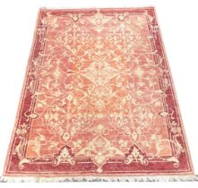 A European red ground rug, decorated with floral and foliate scrolling motifs, 231cm x 172cm.