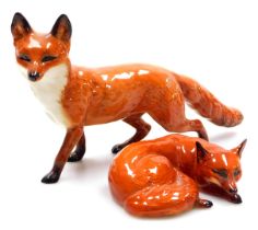 A Beswick pottery figure of a fox, modelled standing, 23cm wide, and a further figure of a recumbent