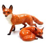 A Beswick pottery figure of a fox, modelled standing, 23cm wide, and a further figure of a recumbent