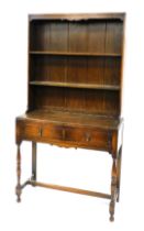 An early 20thC oak dresser, with a two shelf plate rack, above two frieze drawers, raised on turned