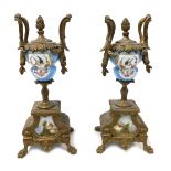 A pair of late 19thC porcelain and brass garniture urns, decorated with reserves of birds and flower