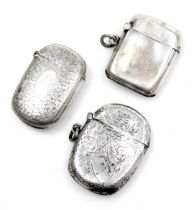 Three silver vesta cases, one of plain form, two with floral and foliate engraving, 1.85oz.