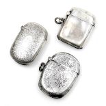 Three silver vesta cases, one of plain form, two with floral and foliate engraving, 1.85oz.