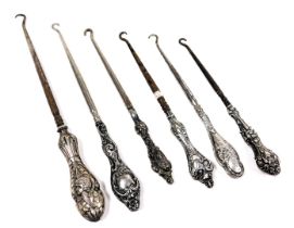 Six Victorian and later silver handled button hooks, with embossed decoration.