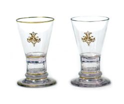 A pair of early 20thC Lobmeyr drinking glasses, the tapering bowls with gilt monograms, raised on a