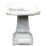 A concrete birdbath, with a square top, raised on a column with floral panels, 48cm high.