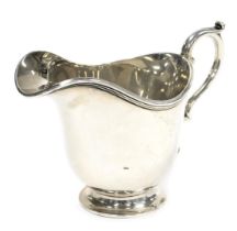 A George V silver cream jug, with a double scroll handle, Hawksworth, Eyre and Company Limited, Shef