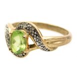 A 9ct gold peridot and diamond ring, in a cross over design, size N, 2.4g.