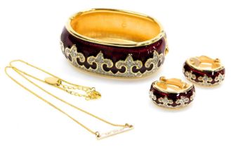 A Swarovski red enamel and crystal bangle and earring set, decorated with fleur de lis against a red