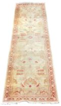 A Turkish cream ground runner, with floral decoration, within a repeating floral border, 297cm x 80c