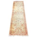 A Turkish cream ground runner, with floral decoration, within a repeating floral border, 297cm x 80c