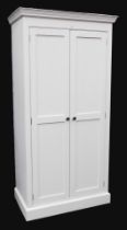 A cream painted pine kitchen cupboard, the outswept pediment over a pair of doors with vacant interi