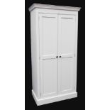 A cream painted pine kitchen cupboard, the outswept pediment over a pair of doors with vacant interi