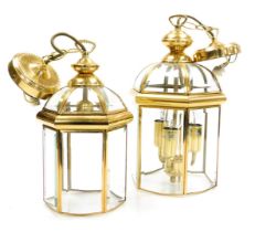 A pair of graduated hexagonal brass framed hall lanterns, with bevelled glass plates, the larger wit