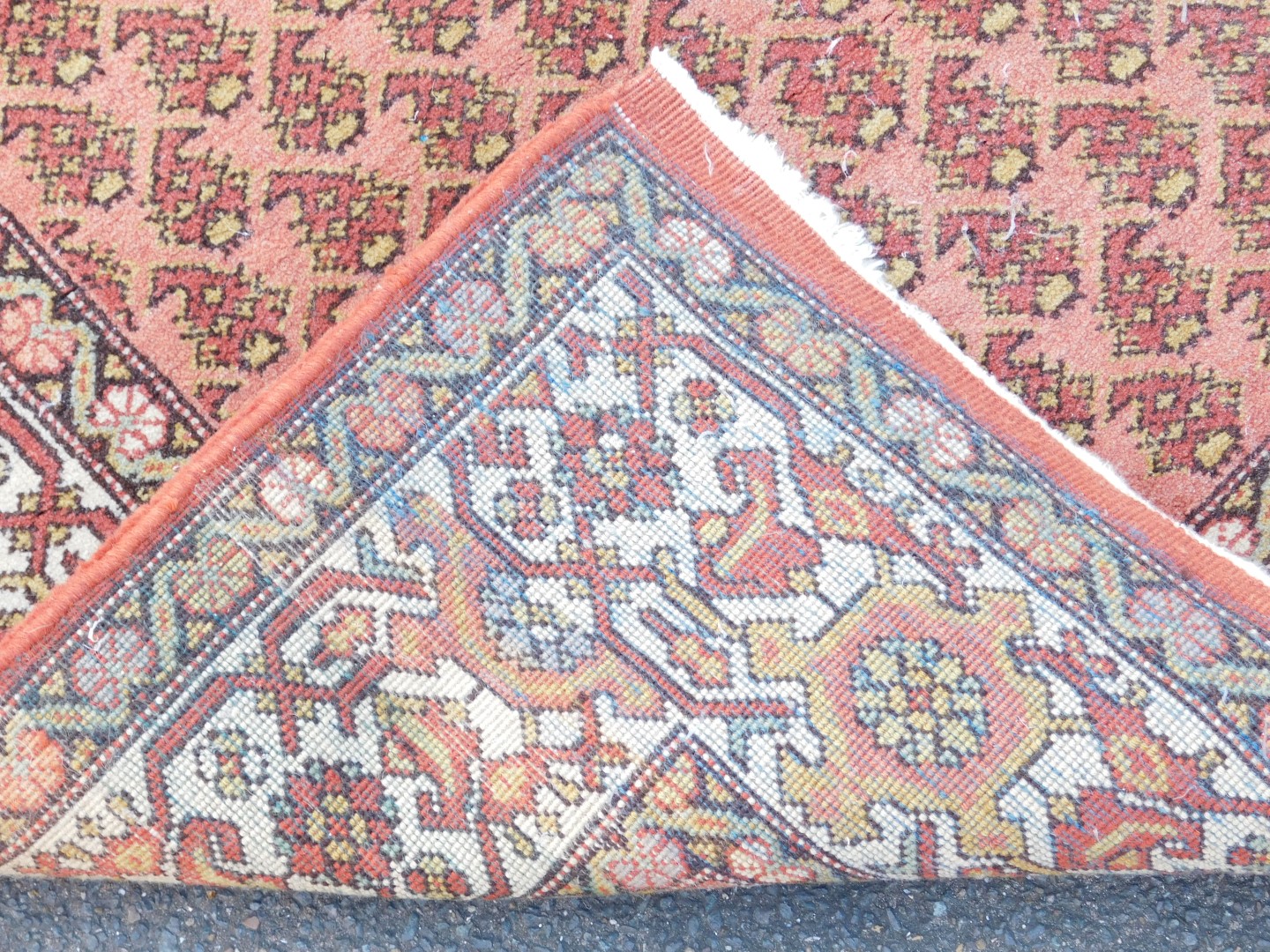 A caucasian red ground rug, the central field decorated with stylised botehs, within repeating flora - Image 3 of 3