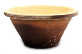 A Victorian terracotta and cream glazed dairy bowl, 18cm high, 37cm wide.