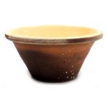 A Victorian terracotta and cream glazed dairy bowl, 18cm high, 37cm wide.