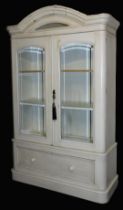 A 19thC French armoire, cream painted, with an outswept pediment, over two glass panelled doors encl