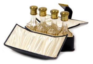 An early 20thC travelling perfume bottle set, comprising four cut glass bottles with gilt metal scre