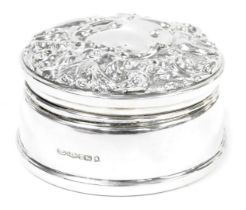 An Elizabeth II loaded silver jewellery box, of circular form, the hinged lid embossed with a mask,