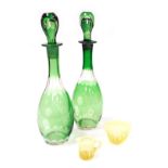 A pair of 20thC Continental green flashed glass decanters, and stoppers, with engraved floral decora