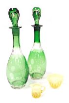 A pair of 20thC Continental green flashed glass decanters, and stoppers, with engraved floral decora
