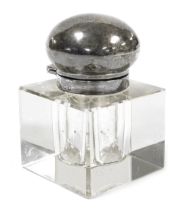 An early 20thC cut glass inkwell, of cube form, with a silver mount and hinged lid, bears indistinct