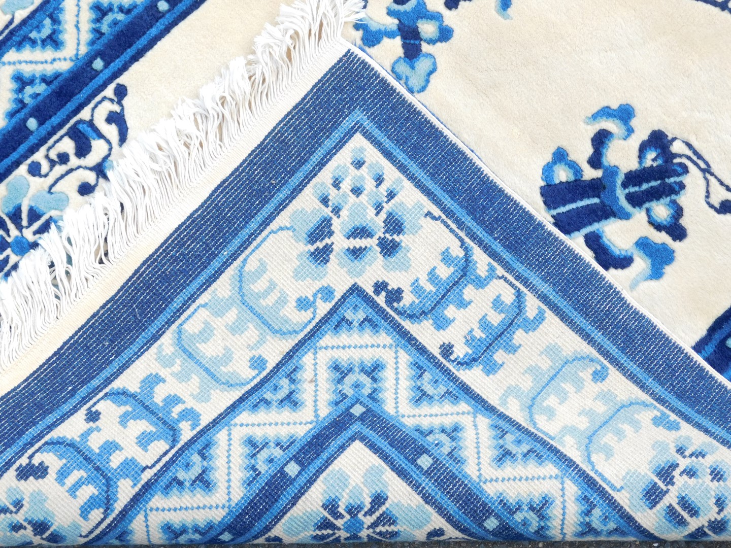 A Chinese blue and cream ground rug, decorated with flowers and buddhist emblems, within repeating f - Image 3 of 3