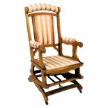 A Victorian beech wood rocking chair, upholstered in salmon pink, gold and cream floral striped fabr